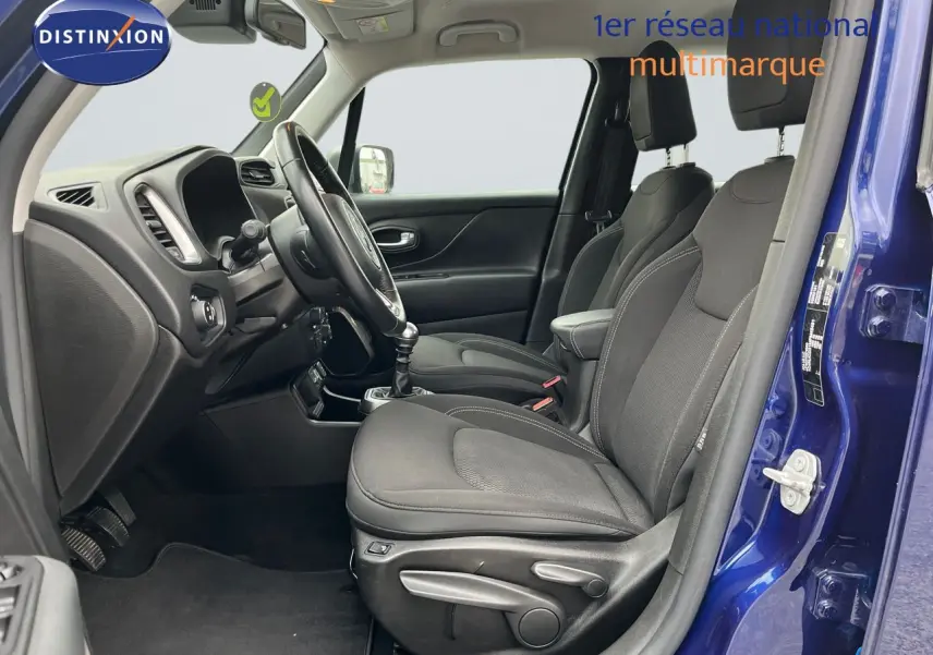Intérieur côté conducteur du Jeep Renegade bleu 2020, montrant sièges noirs et tableau de bord avec boîte manuelle.