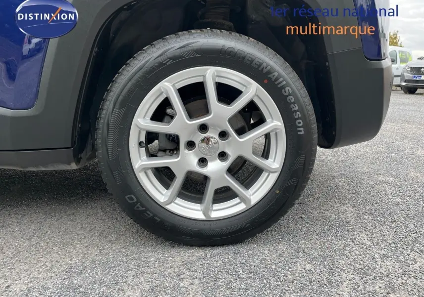 Gros plan sur la roue avant droite d’un Jeep Renegade bleu 2020 avec jante argentée et pneu toutes saisons.