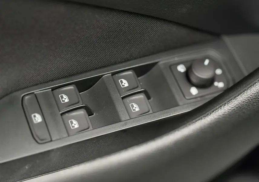 Gros plan sur les commandes des vitres et rétroviseurs côté conducteur de la Skoda Kamiq gris argent 2025.
