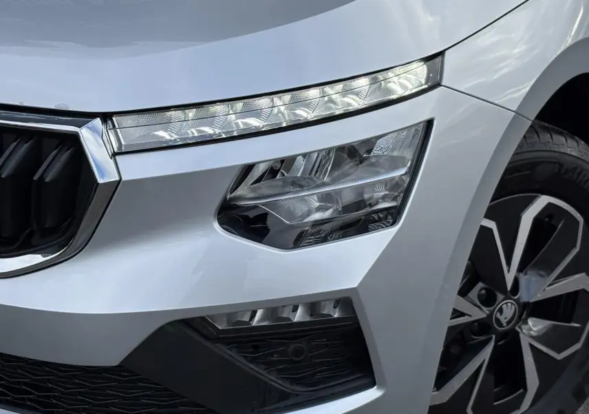 Gros plan sur l'avant droit gris argent du Skoda Kamiq 2025, mettant en valeur les phares Full LED et la jante alliage.