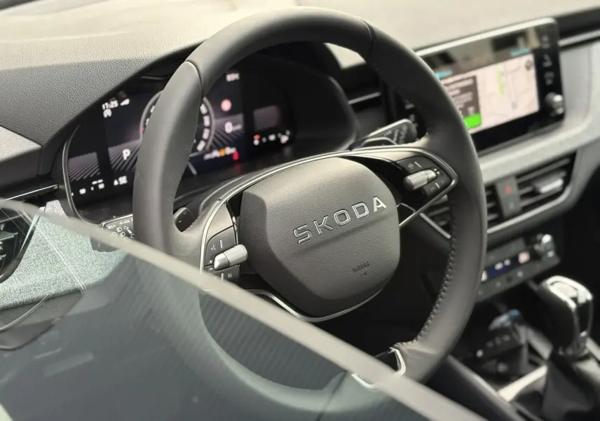 Vue intérieure rapprochée du volant cuir multifonctions SKODA du KAMIQ 2025 avec tableau de bord digital et écran tactile.
