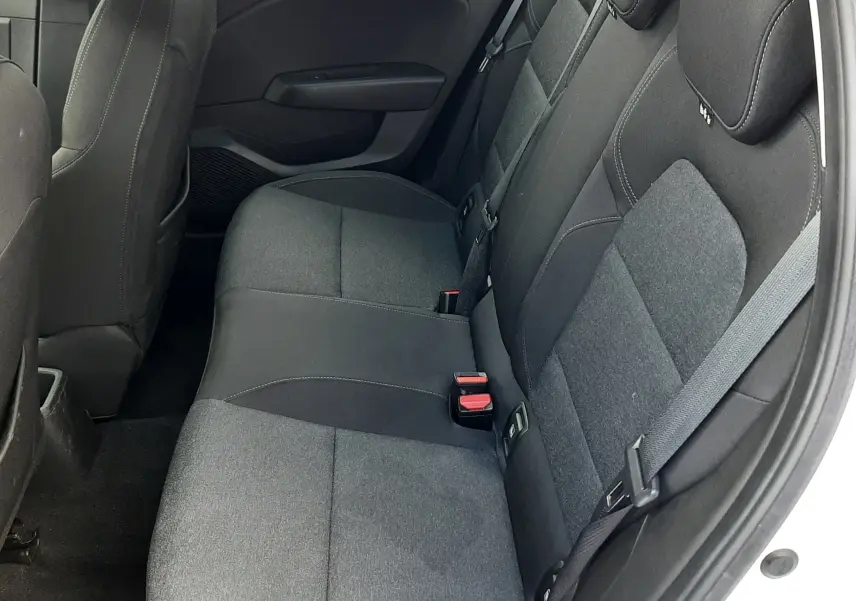 Vue intérieure côté droit des sièges arrière noirs en tissu de la Renault Clio V blanche, avec ceinture de sécurité visible.