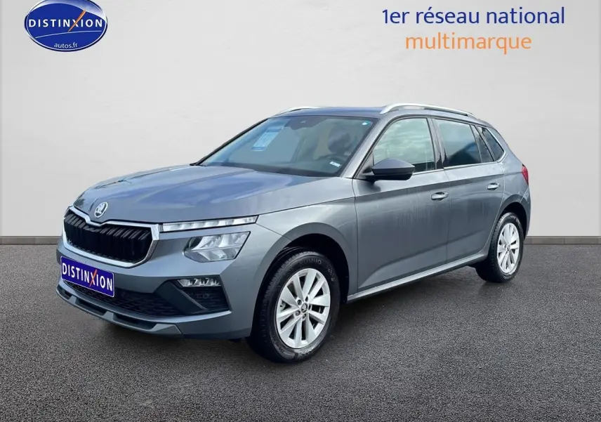 Vue 3/4 avant droit d'un Skoda Kamiq gris avec calandre chromée et jantes alu blanches.