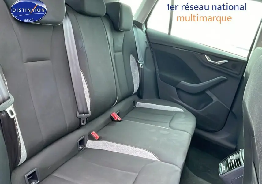 Vue intérieure arrière côté droit du Skoda Kamiq gris, montrant la banquette 3 places avec ceintures et appuie-têtes.