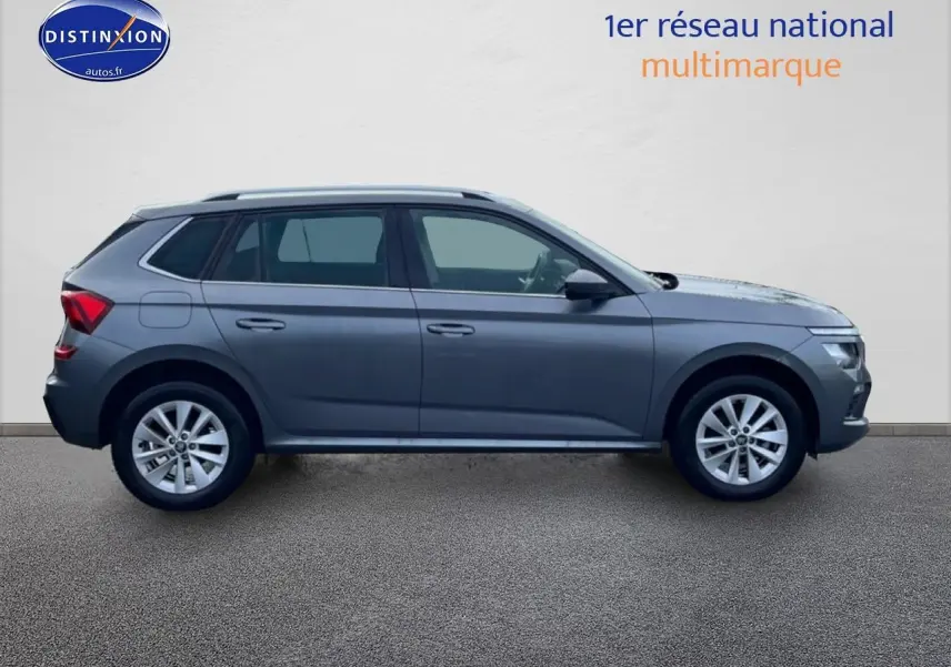Vue latérale droite d'un Skoda Kamiq gris 2025 avec jantes alu et barres de toit visibles.