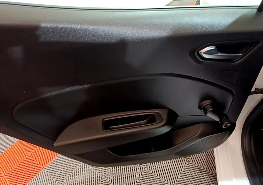 Vue intérieure côté gauche de la porte avant d'une Renault Clio Business blanche avec manivelle de vitre manuelle.