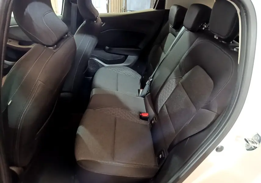 Vue intérieure côté droit sur la banquette arrière noire de la Renault Clio Business blanche, avec ceinture de sécurité visible.