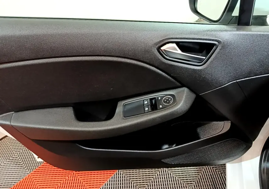 Vue intérieure sur la porte avant gauche noire de la Renault Clio Business blanche, avec commandes des vitres et rétroviseurs.