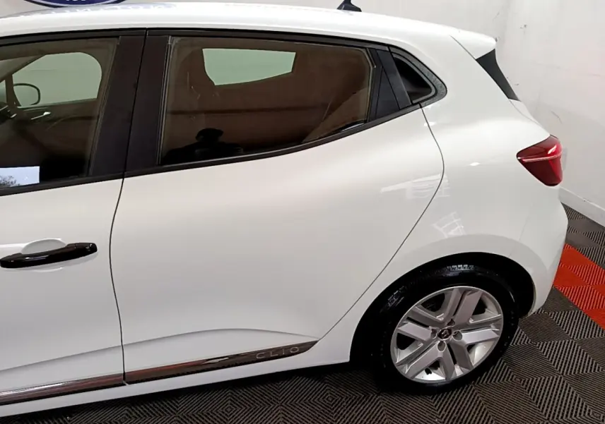 Vue côté droit arrière de la Renault Clio Business blanche, avec jante alliage et feux arrière LED visibles.