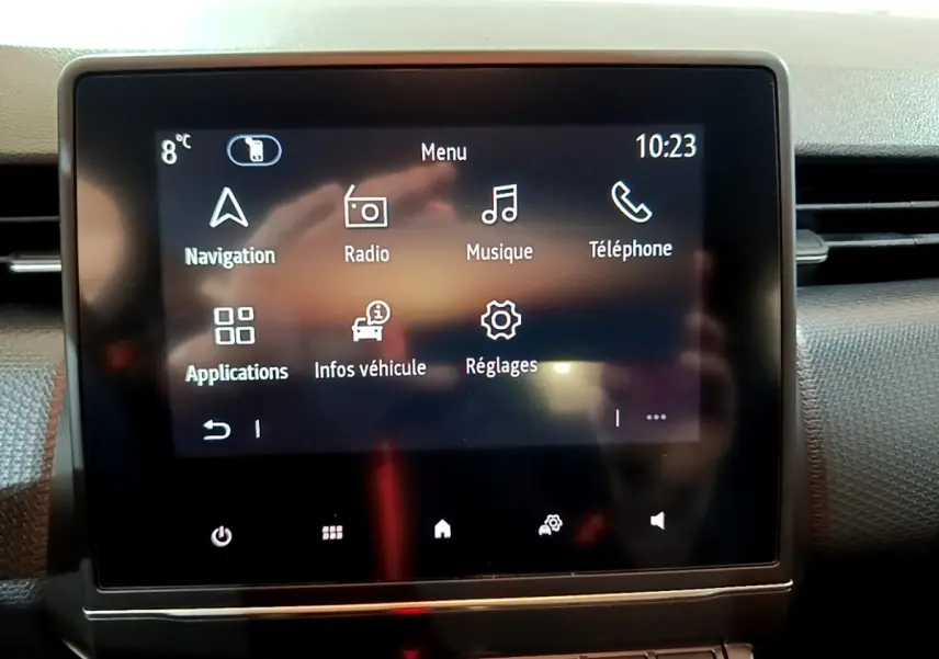Écran tactile central affichant le menu multimédia de la Renault Clio Business blanche, vue intérieure frontale.