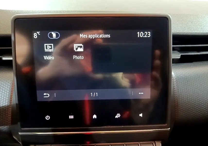 Écran tactile central affichant les applications vidéo et photo dans l’habitacle d’une Renault Clio Business blanche.