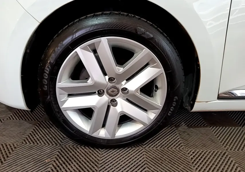 Gros plan sur la roue avant droite blanche d'une Renault Clio Business 2021 avec jante alliage et logo Renault central.