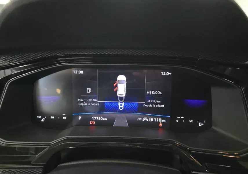 Vue rapprochée du tableau de bord numérique de la Volkswagen Polo gris 2025 avec affichage des alertes et kilométrage.