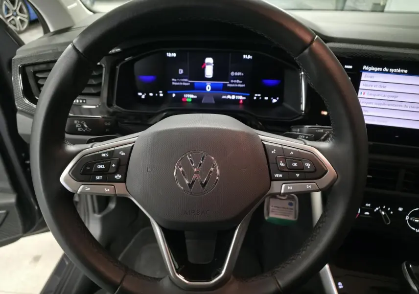 Vue rapprochée du volant cuir multifonction noir de la Volkswagen Polo 2025 avec tableau de bord digital et écran tactile.