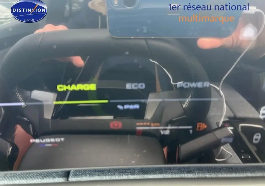 Vue rapprochée du tableau de bord numérique et du volant cuir du Peugeot 3008 gris Artense hybride 2025.