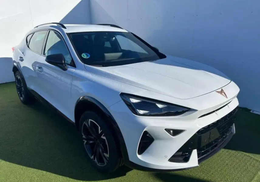 Vue 3/4 avant droite d'un CUPRA Formentor blanc 2025 avec phares LED et jantes noires distinctives.