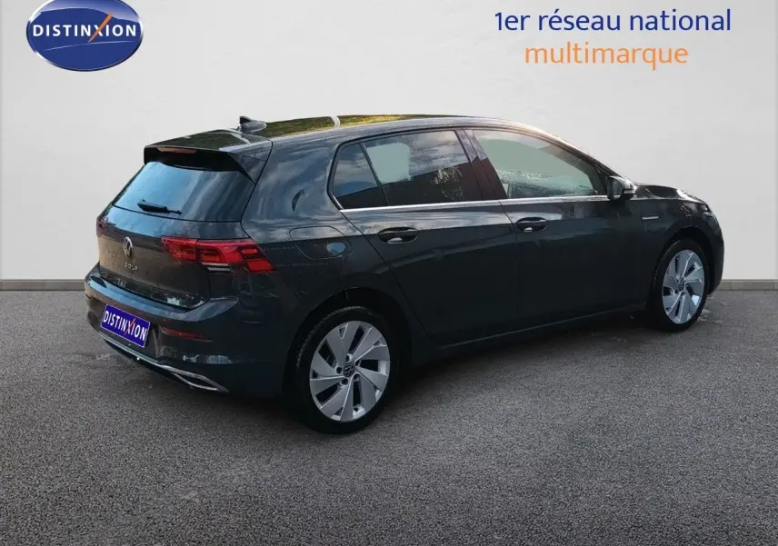 Vue 3/4 arrière droite d'une Volkswagen Golf 1.5 TSI Style gris Urano avec jantes alliage et vitres teintées.