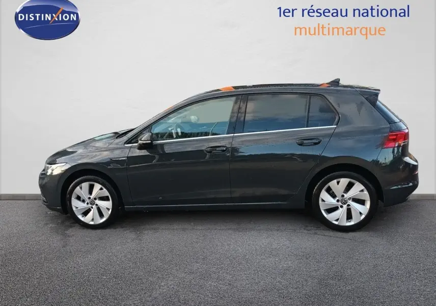 Vue de profil côté gauche d'une Volkswagen Golf 1.5 TSI 130CH Style gris Urano avec jantes alliage et vitres teintées.