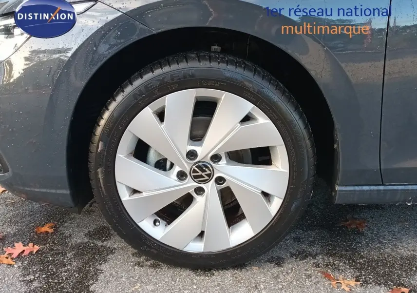 Gros plan sur la roue avant gauche d'une Volkswagen Golf 1.5 TSI 130ch Style gris Urano avec jante alliage 17 pouces.