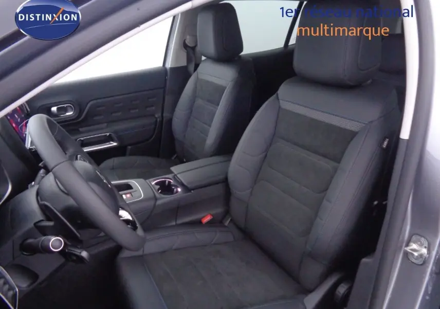 Intérieur du Citroën C5 Aircross 2022, vue centrale sur la console et l'écran tactile avec finitions noires et surpiqûres bleues.