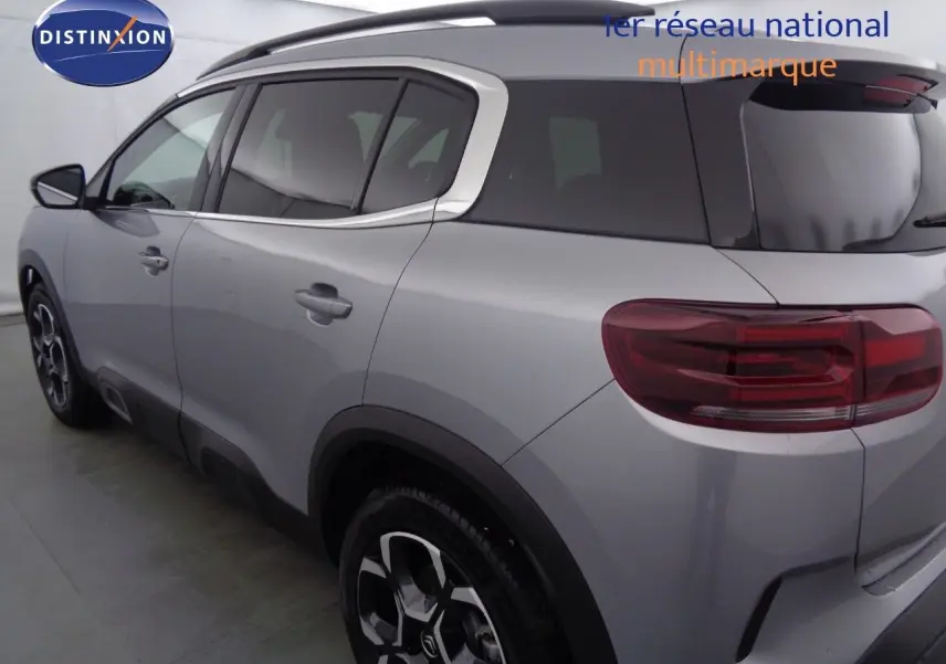 Profil côté gauche du Citroën C5 Aircross gris Artense métal avec jantes bi-ton et barres de toit noires.