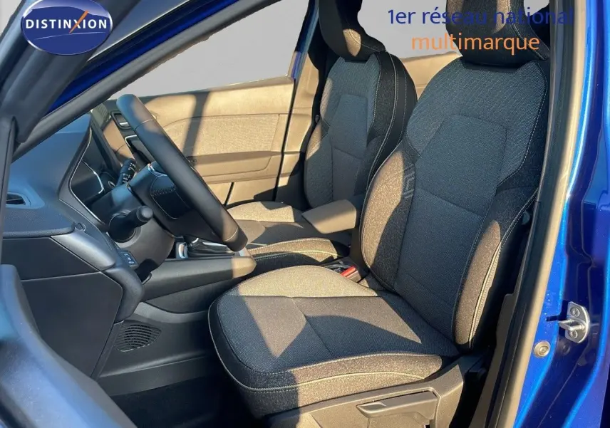 Vue intérieure côté conducteur du Renault Captur E-Tech Hybrid 2025 avec sièges tissu gris et bleu iron metal visible.