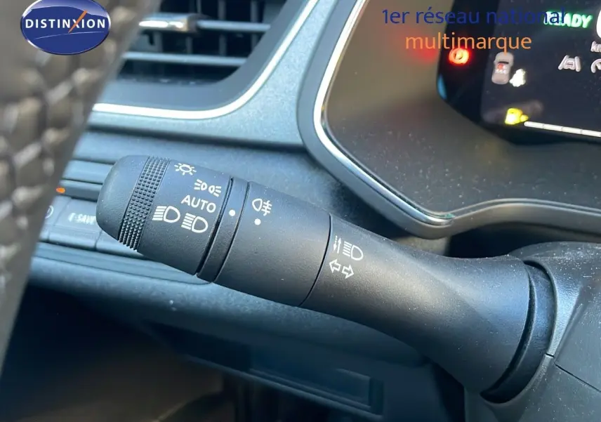 Gros plan sur la commande des phares et clignotants du Renault Captur E-Tech Hybrid 2025, intérieur noir.