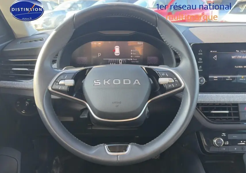 Vue intérieure centrée sur le volant cuir noir SKODA KAMIQ 2025 avec tableau de bord numérique et écran tactile.