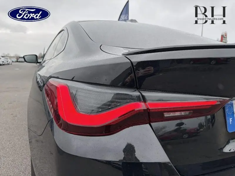 Gros plan sur le feu arrière gauche rouge d'une BMW Série 4 Gran Coupé F36 Saphirschwarz métallisé, vue 3/4 arrière.