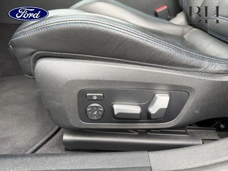 Détail des commandes électriques du siège avant en cuir noir avec surpiqûres bleues d'une BMW Série 4 Gran Coupe F36 Saphirschwarz.