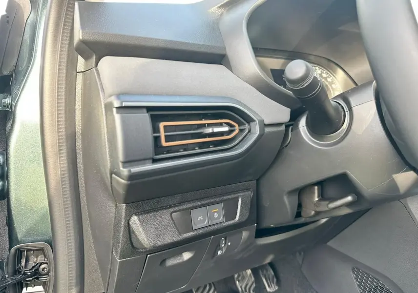 Vue intérieure côté gauche du tableau de bord vert cèdre de la Dacia Sandero III Stepway avec sortie d’air et bouton LPG.