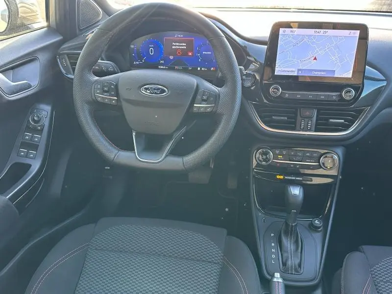 Vue intérieure centrée sur le volant et le tableau de bord du Ford Puma 2024, avec écran tactile et commandes au volant.