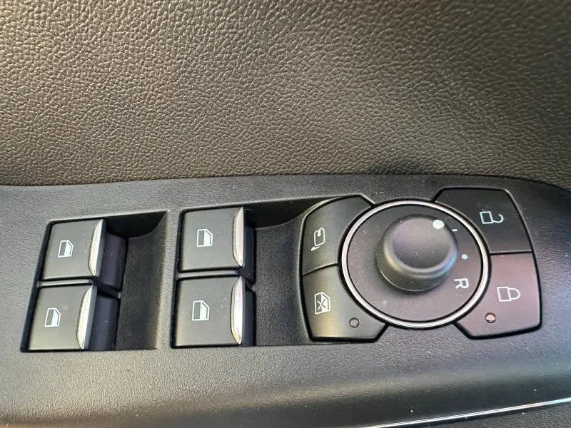 Commande des vitres et réglage des rétroviseurs côté conducteur du Ford Puma 2024 finition ST-Line en intérieur noir.