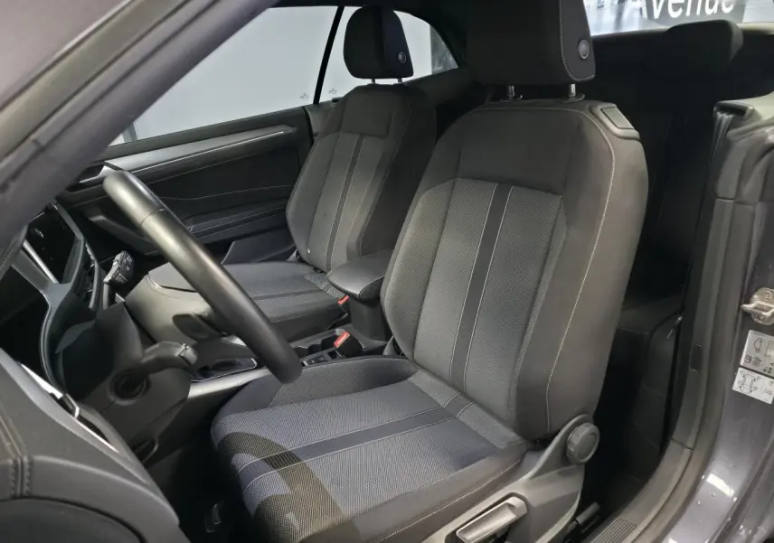 Vue intérieure côté gauche sur les sièges avant en tissu noir du Volkswagen T-Roc Cabriolet gris 2024.