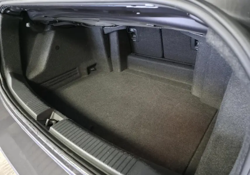 Coffre ouvert vu de dessus du Volkswagen T-Roc Cabriolet gris 2024, montrant l'espace de rangement intérieur.