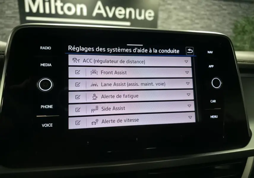 Écran tactile du tableau de bord du Volkswagen T-Roc gris 2024 affichant les réglages des aides à la conduite.
