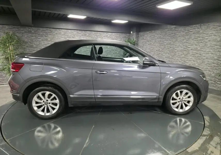 Volkswagen T-Roc cabriolet gris métallisé vue de profil côté gauche, capote noire fermée, jantes alliage 17 pouces.