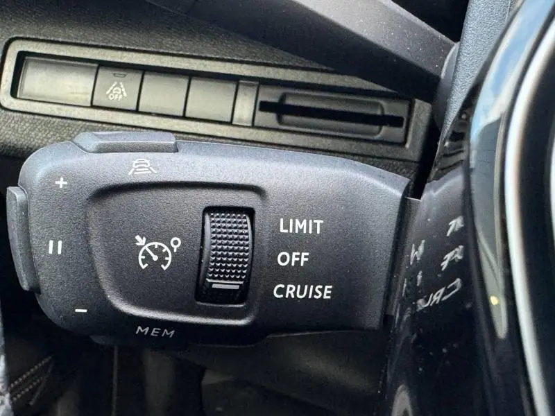 Gros plan sur la commande de régulateur de vitesse noire du Peugeot 3008 2024, côté gauche du volant.