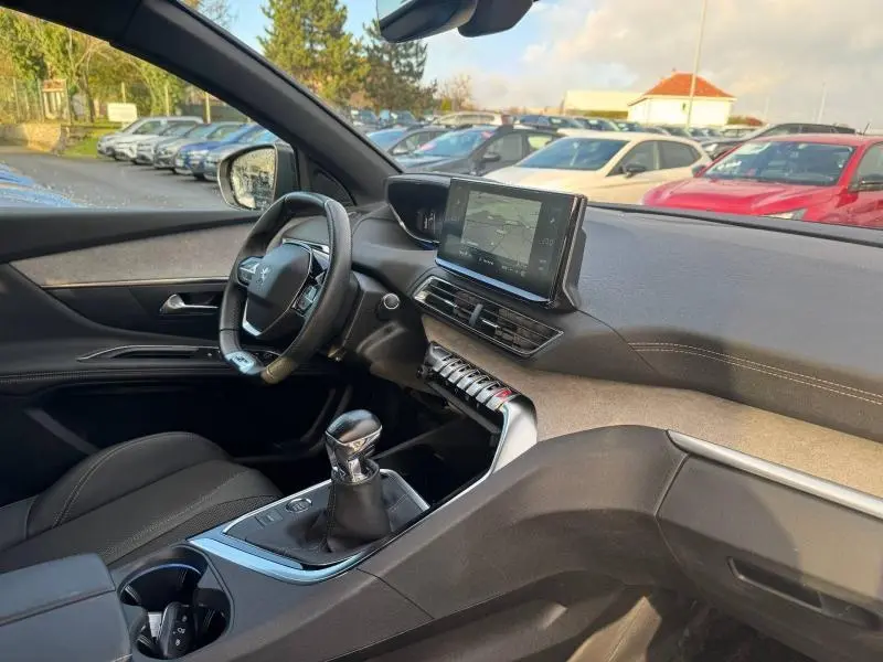 Intérieur du Peugeot 3008 2024 noir, vue côté gauche sur le tableau de bord et la console avec boîte manuelle.