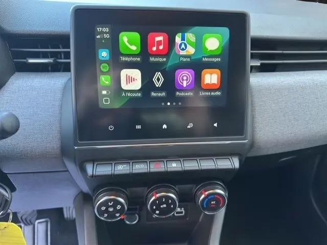 Vue rapprochée du tableau de bord de la Renault Clio noire 2025 avec écran tactile central affichant Apple CarPlay.