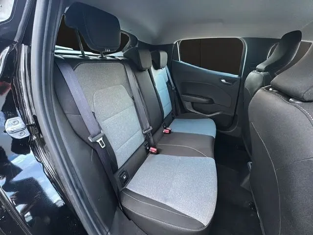 Vue intérieure arrière côté gauche d'une Renault Clio noire, montrant la banquette 3 places bicolore avec ceintures de sécurité.
