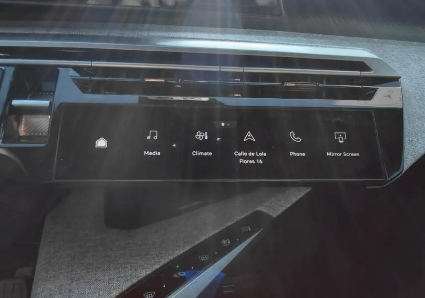 Vue rapprochée du tableau de bord du Peugeot 5008 Hybrid 2025, mettant en valeur l'écran tactile et la molette de boîte automatique.