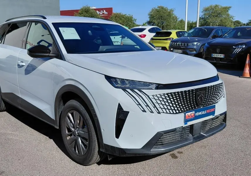 Peugeot 5008 Hybrid blanc vue 3/4 avant droit, calandre moderne avec logo lion et jantes alliage.