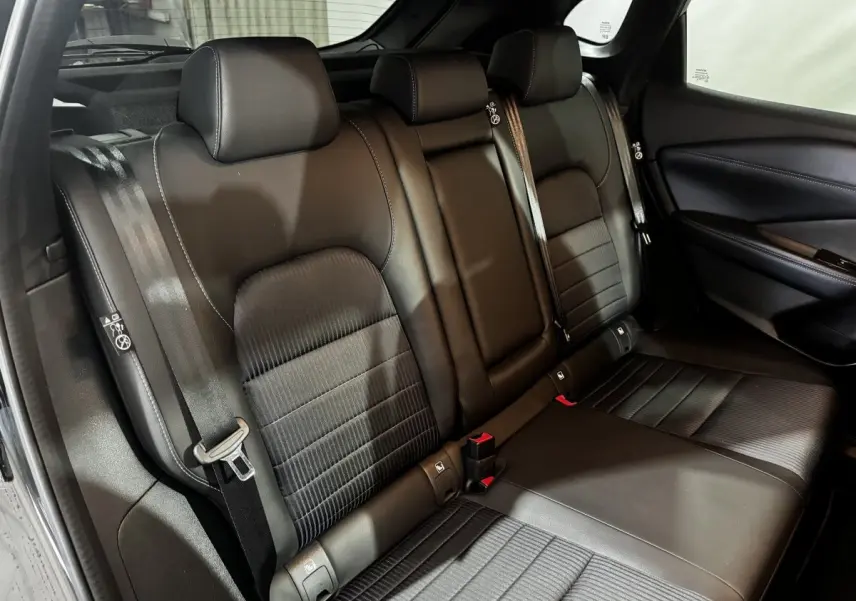 Vue intérieure du siège arrière noir en cuir du Nissan Qashqai e-Power 190 Tekna BVA 2023, avec ceintures de sécurité visibles.
