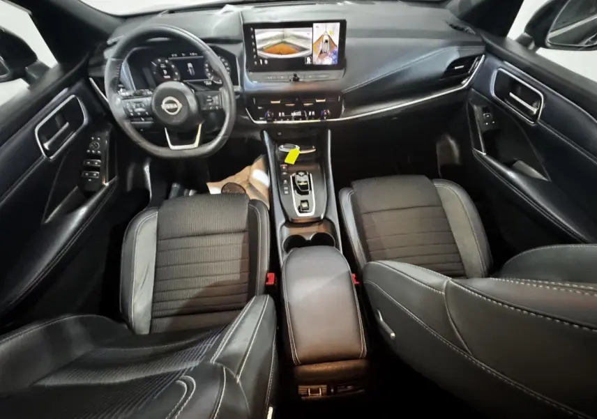 Intérieur noir du Nissan Qashqai e-Power 190 Tekna 2023 vu de dessus, avec tableau de bord digital et écran tactile central.