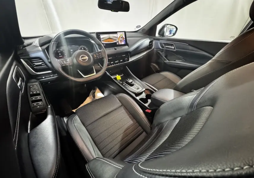 Intérieur noir du Nissan Qashqai e-Power 190 Tekna 2023, vue côté conducteur avec tableau de bord et écran tactile.