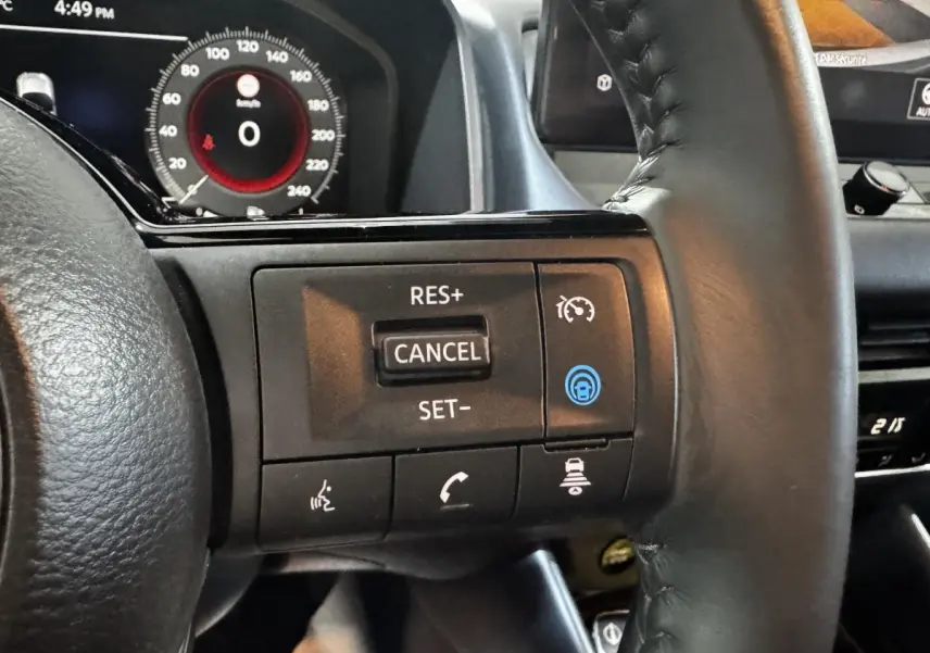 Gros plan sur le volant noir du Nissan Qashqai e-Power 190 Tekna 2023, avec commandes de régulateur de vitesse et affichage numérique en arrière-plan.