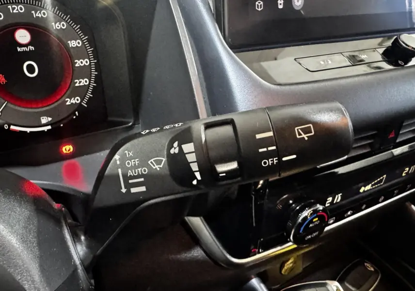 Gros plan sur la commande d’essuie-glace et le tableau de bord numérique du Nissan Qashqai e-Power noir 2023.
