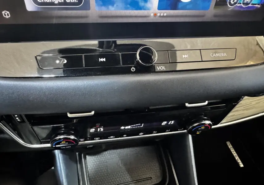 Détail de la console centrale noire du Nissan Qashqai e-Power 190 Tekna avec commandes volume et climatisation.