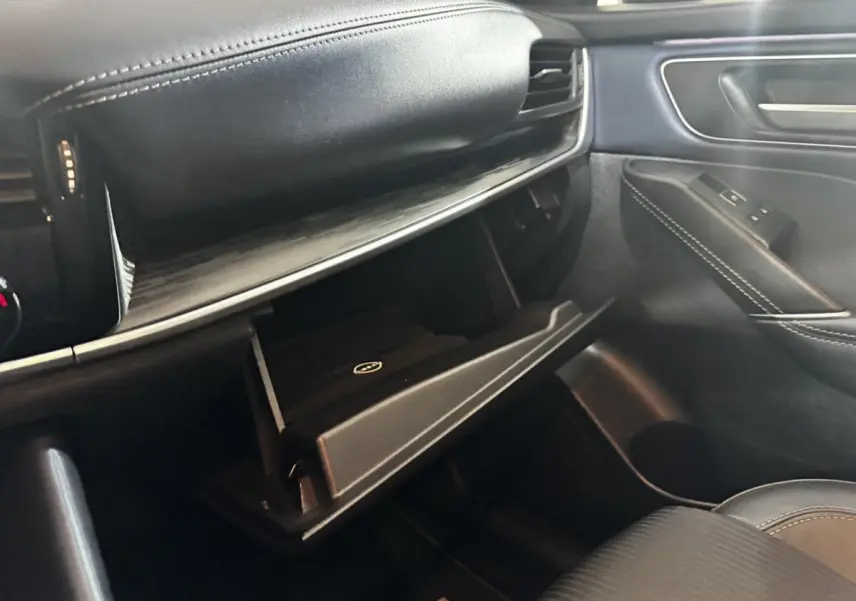 Intérieur noir du Nissan Qashqai e-Power 2023, vue côté passager avec boîte à gants ouverte et finitions cuir.